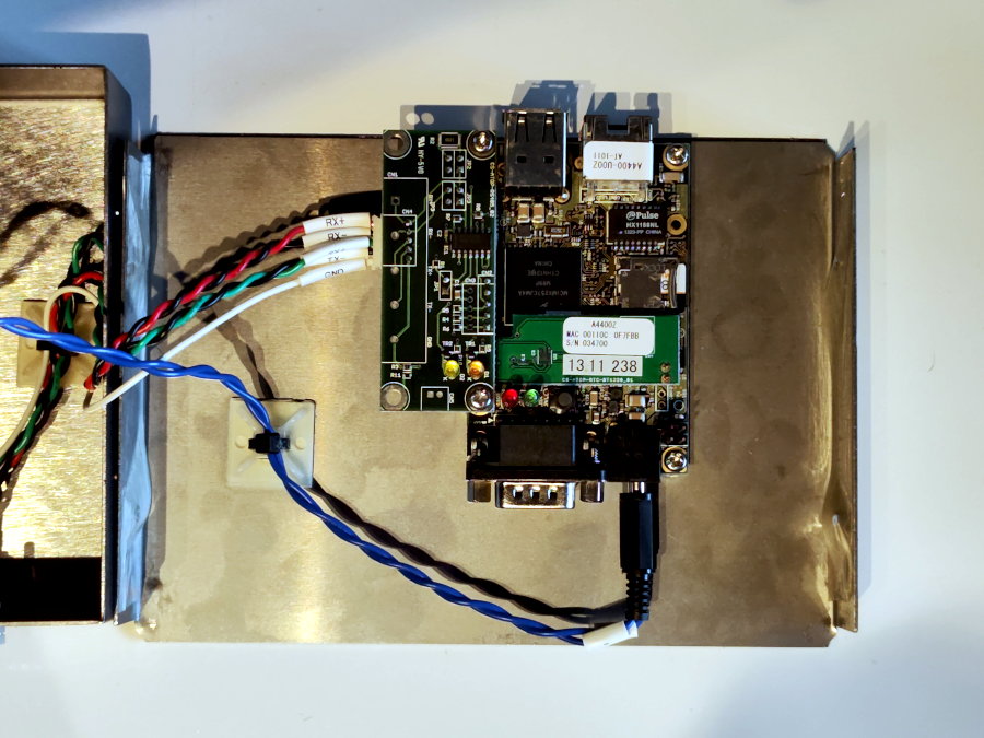 The image shows an open metal box, inside of which are an SBC and some cables. The structure is simple and consists mainly of standard components connected to each other.